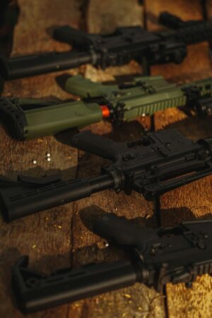 A diverse set of rifles arranged on a rustic wooden surface, highlighting contrasts.